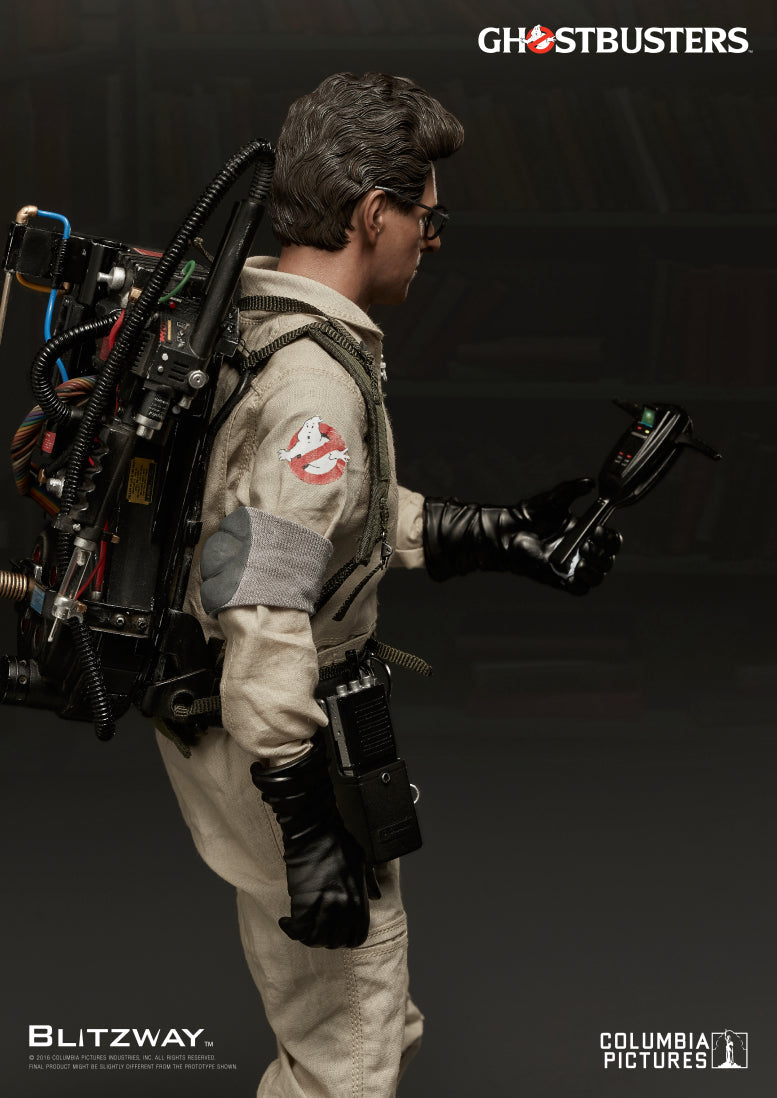 Side view of Blitzway's 1/6 scale Action Figure of Egon Spengler from Ghostbusters, showing him scanning with a P.K.E. Meter while wearing a proton pack with detailed wiring and textures.