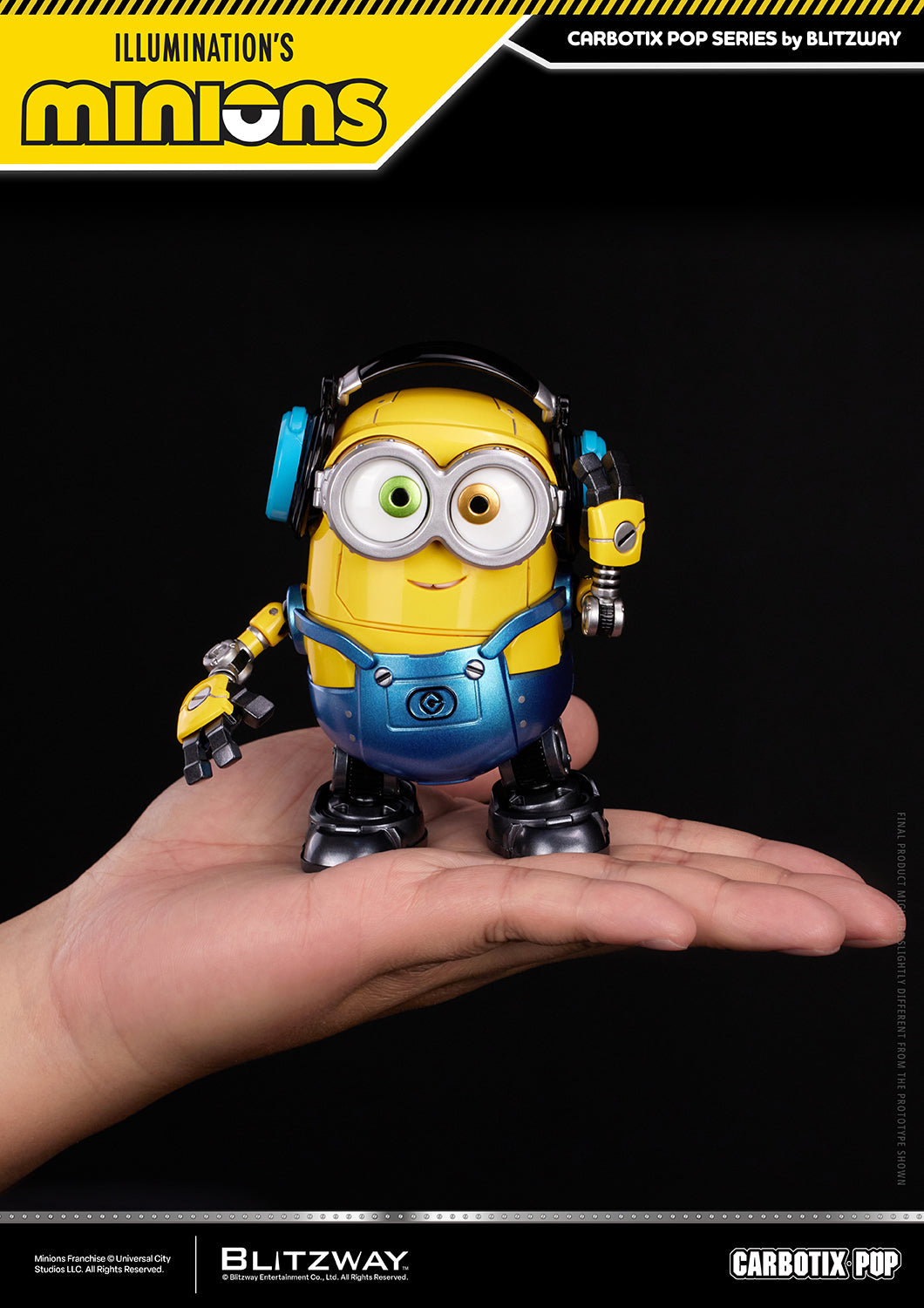 Bob from the CARBOTIX Pop Minions series by Blitzway displayed on a person's hand for size comparison. The robot-style collectible wears blue headphones, features Bob's signature mismatched green and brown eyes, articulated mechanical joints, and a compact palm-sized design.